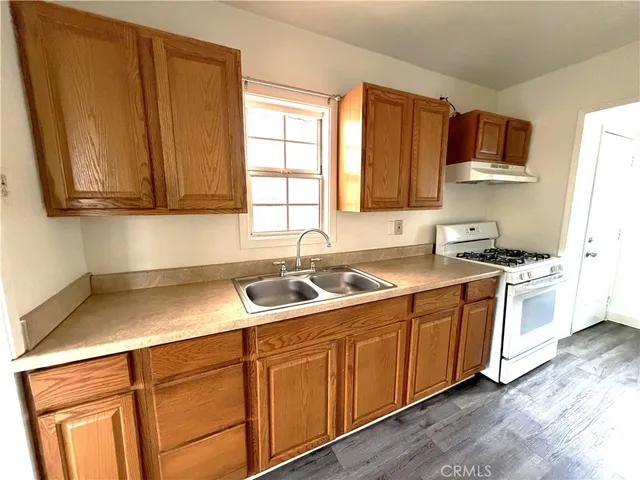 a kitchen with stainless steel appliances granite countertop a sink stove and microwave