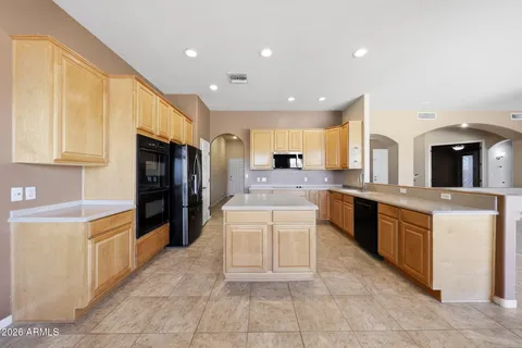 a large white kitchen with a large window and kitchen