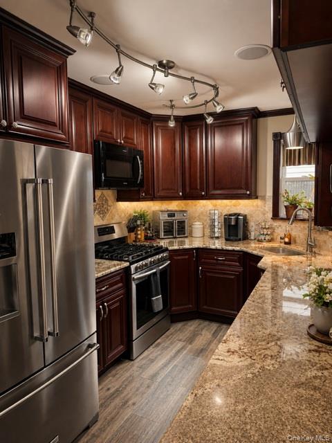 700 Sharon Road Copiague, NY 11726 - Photo 5 of 27 a kitchen with granite countertop stainless steel appliances and wooden cabinets