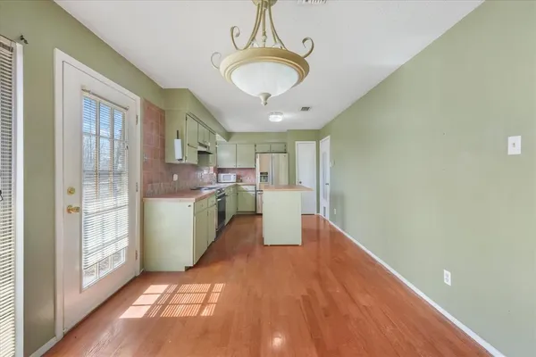 a view of a kitchen with fridge and windows