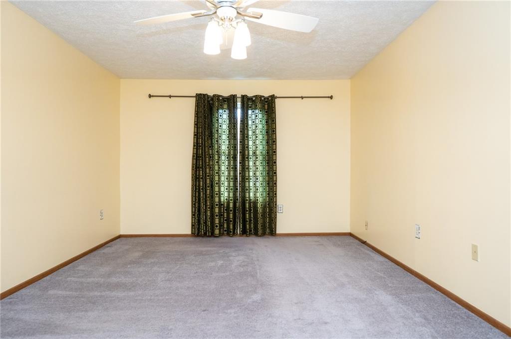 7324 Green Meadow Drive Imperial, PA 15126 - Photo 13 of 43 an empty room with a chandelier fan and windows
