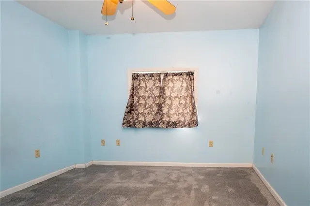 an empty room with a bathroom and mirror