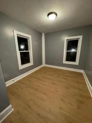 a view of an empty room with a fireplace and wooden floor