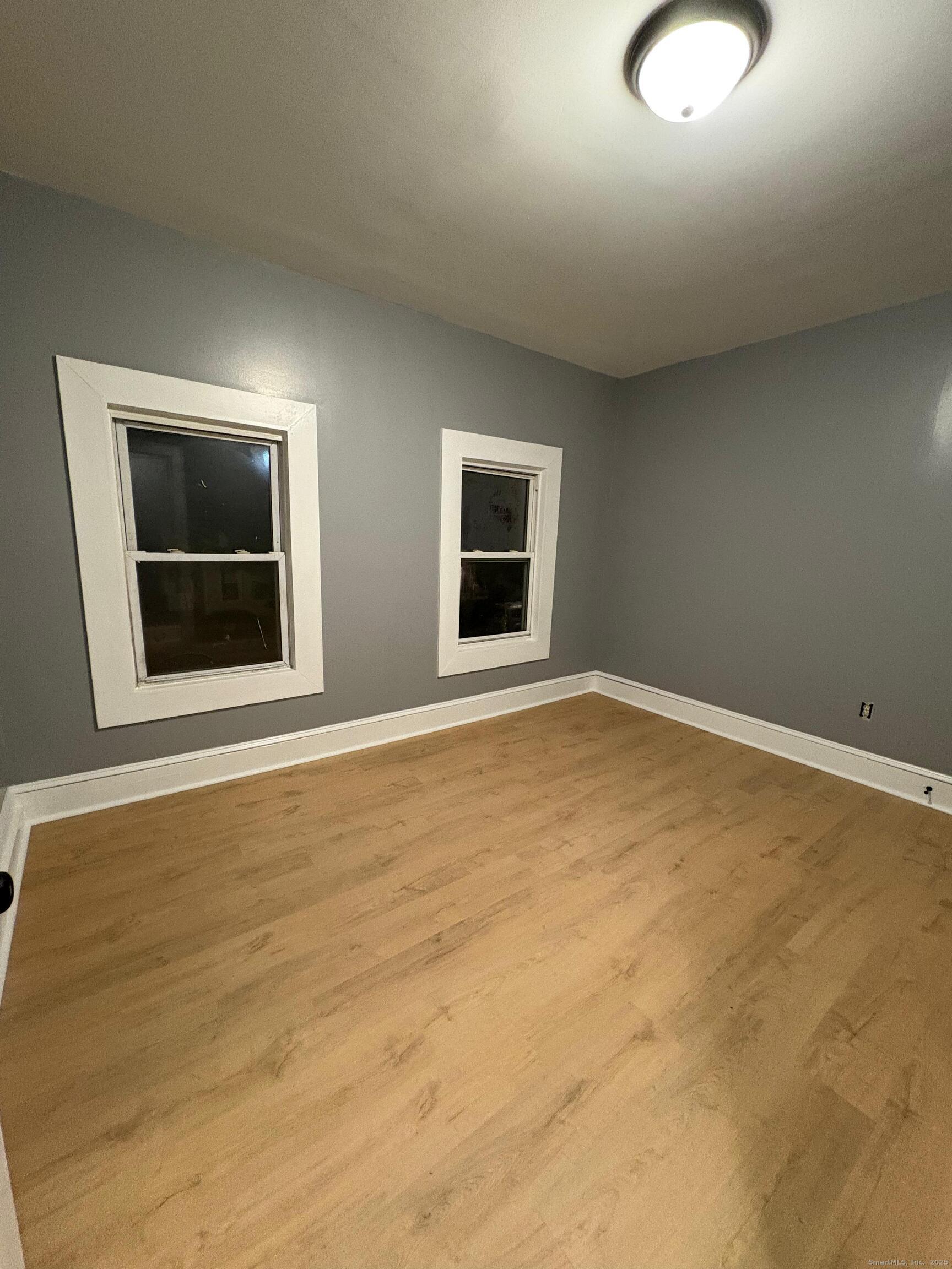 409 Poplar Street New Haven, CT 06513 - Photo 5 of 14 a view of an empty room with wooden floor and a window