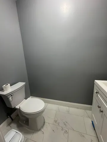 a white toilet sitting next to a shower