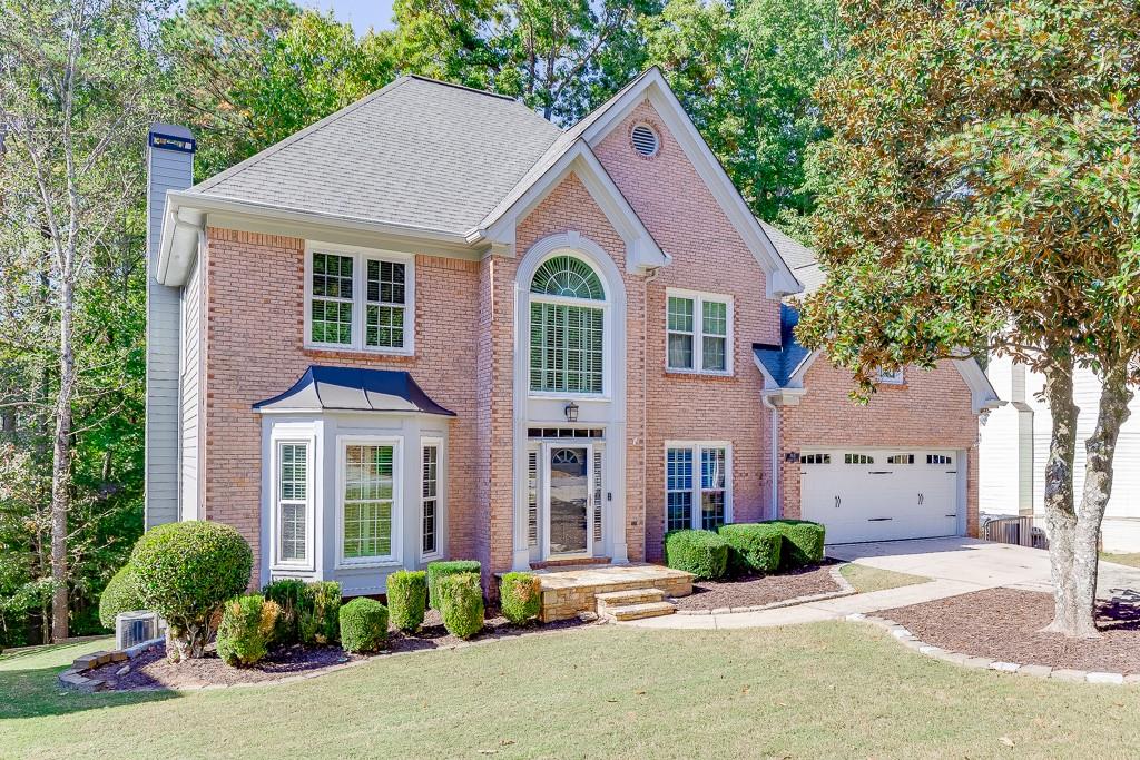 765 Amberton Close Suwanee, GA 30024 - Photo 1 of 1 a front view of a house with a yard and potted plants