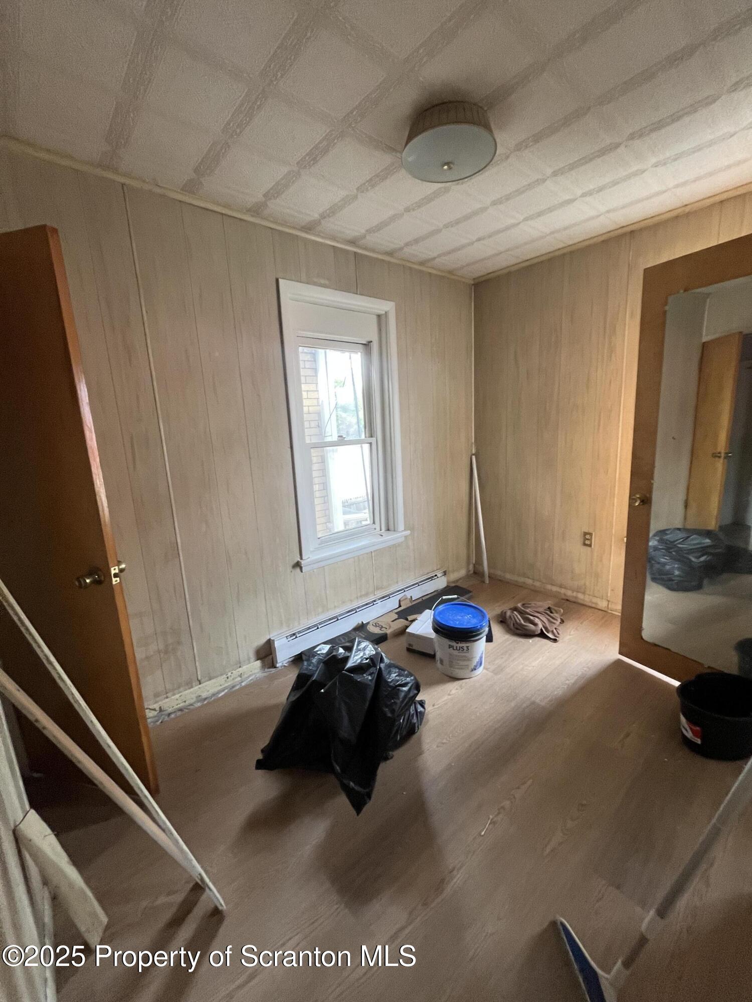 219 Ash Street Scranton, PA 18509 - Photo 8 of 11 a bed sitting in a bedroom next to a window