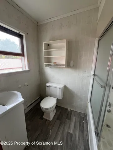 a bathroom with a toilet a sink and a window