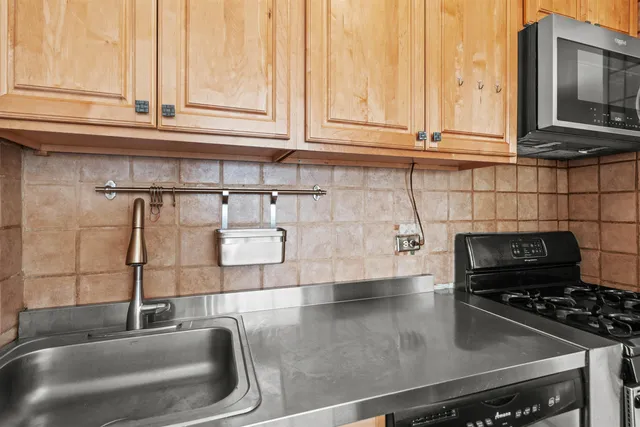 a kitchen with granite countertop a sink stainless steel appliances and cabinets