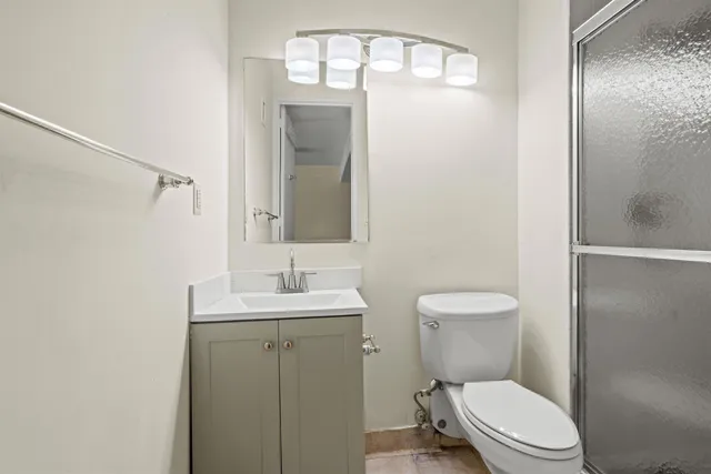 a bathroom with a toilet a sink and mirror