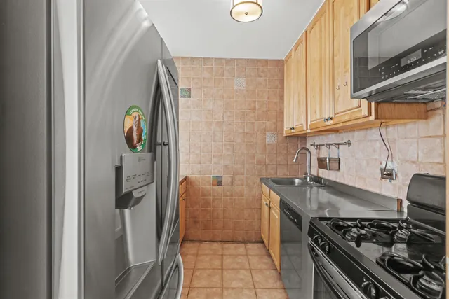 a kitchen with stainless steel appliances granite countertop a stove and a refrigerator