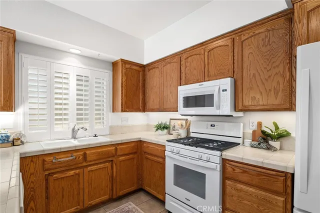 a kitchen with stainless steel appliances granite countertop a sink a stove and a microwave