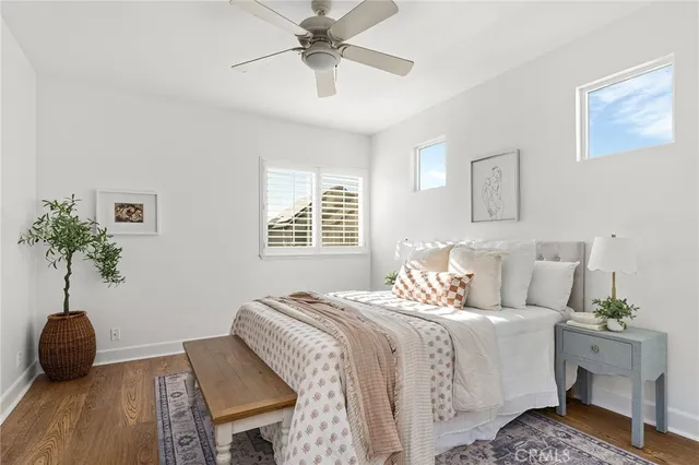 a bedroom with a bed a couch and potted plant