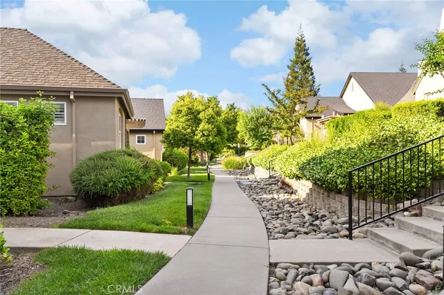 a front view of a house with a yard and potted plants