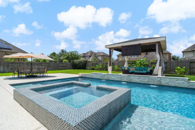 a view of swimming pool with outdoor seating and a garden