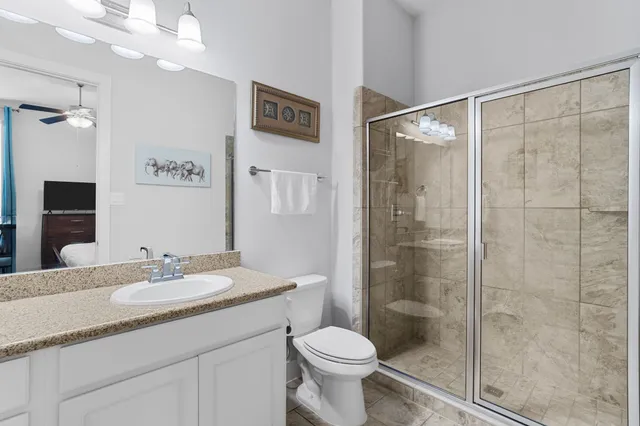 a bathroom with a shower sink vanity and toilet