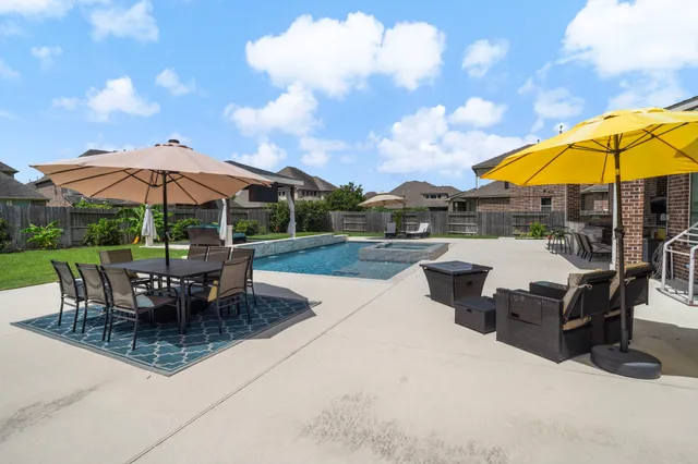 a view of a patio with a table and chairs under an umbrella