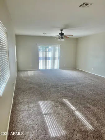 an empty room with windows and ceiling fan