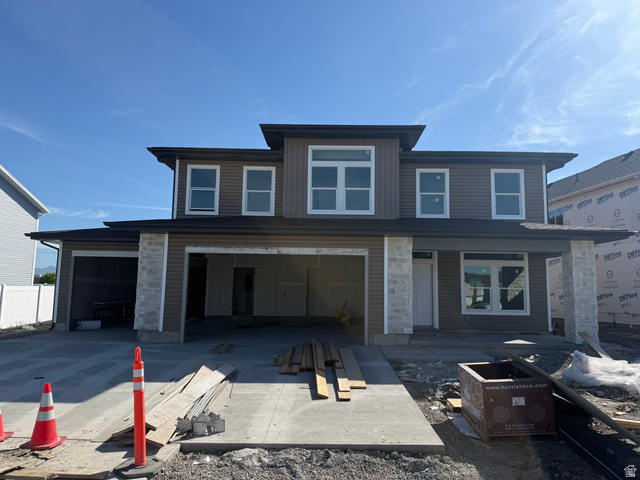 Modern two-story home featuring a combination of horizontal siding and stone veneer accents