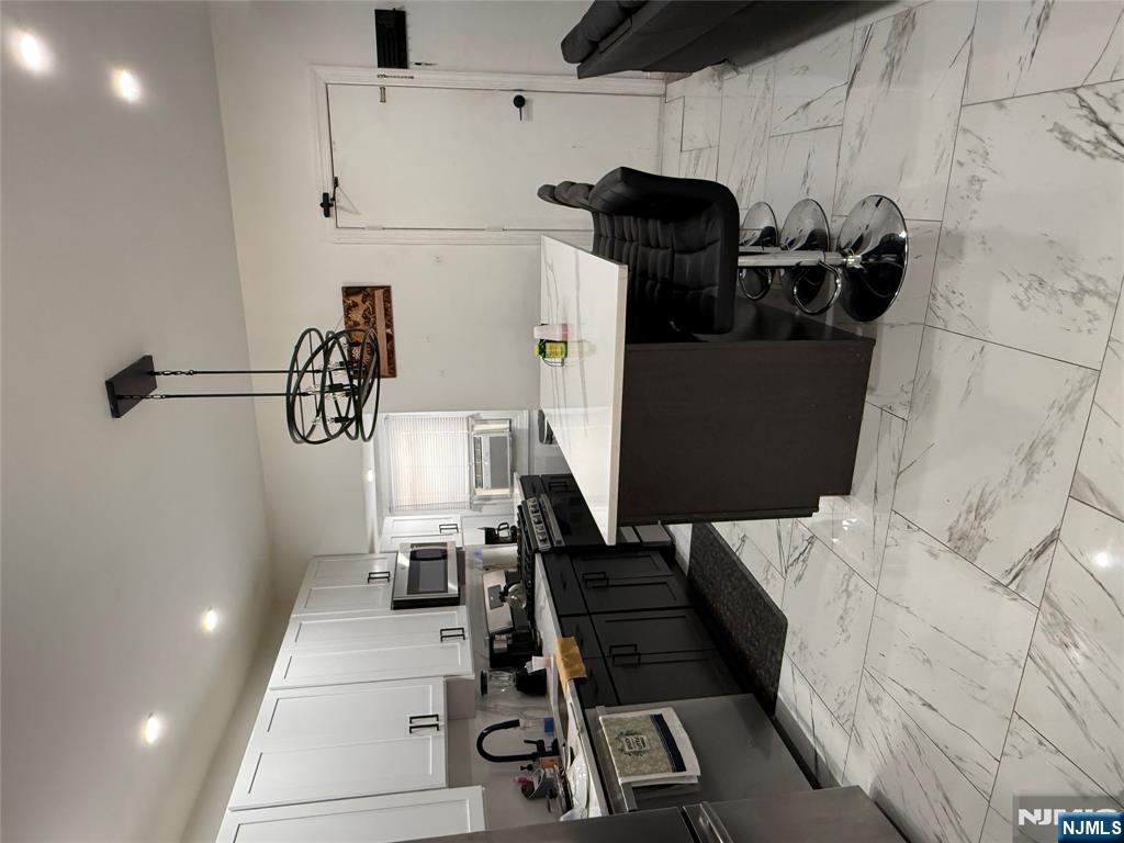 149 Camden Street Newark, NJ 07103 - Photo 2 of 3 a kitchen with stainless steel appliances kitchen island granite countertop a sink counter space and a view of living room