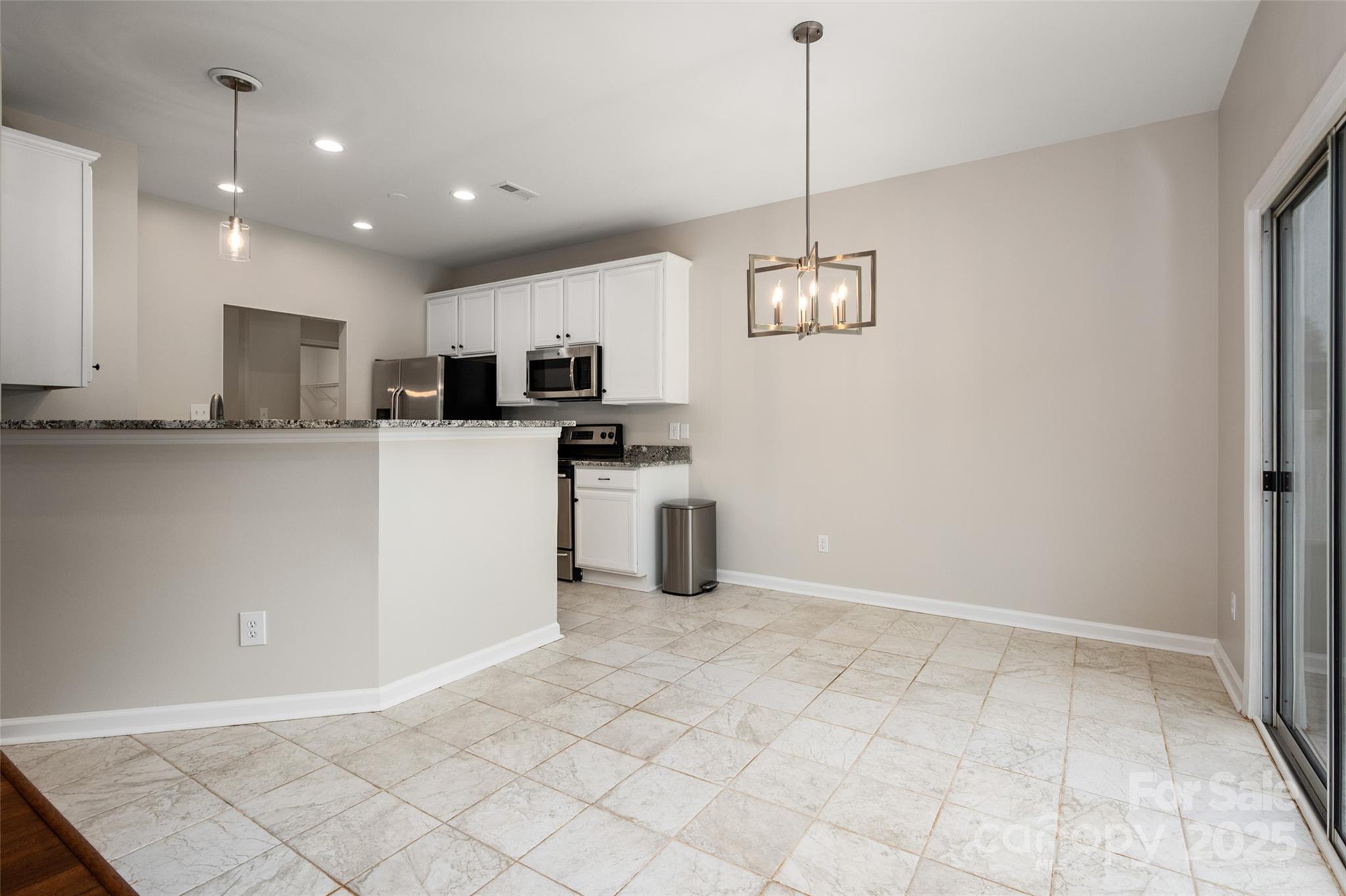 1004 Toquima Trail Monroe, NC 28110 - Photo 16 of 38 a kitchen with granite countertop a stove a sink and a refrigerator