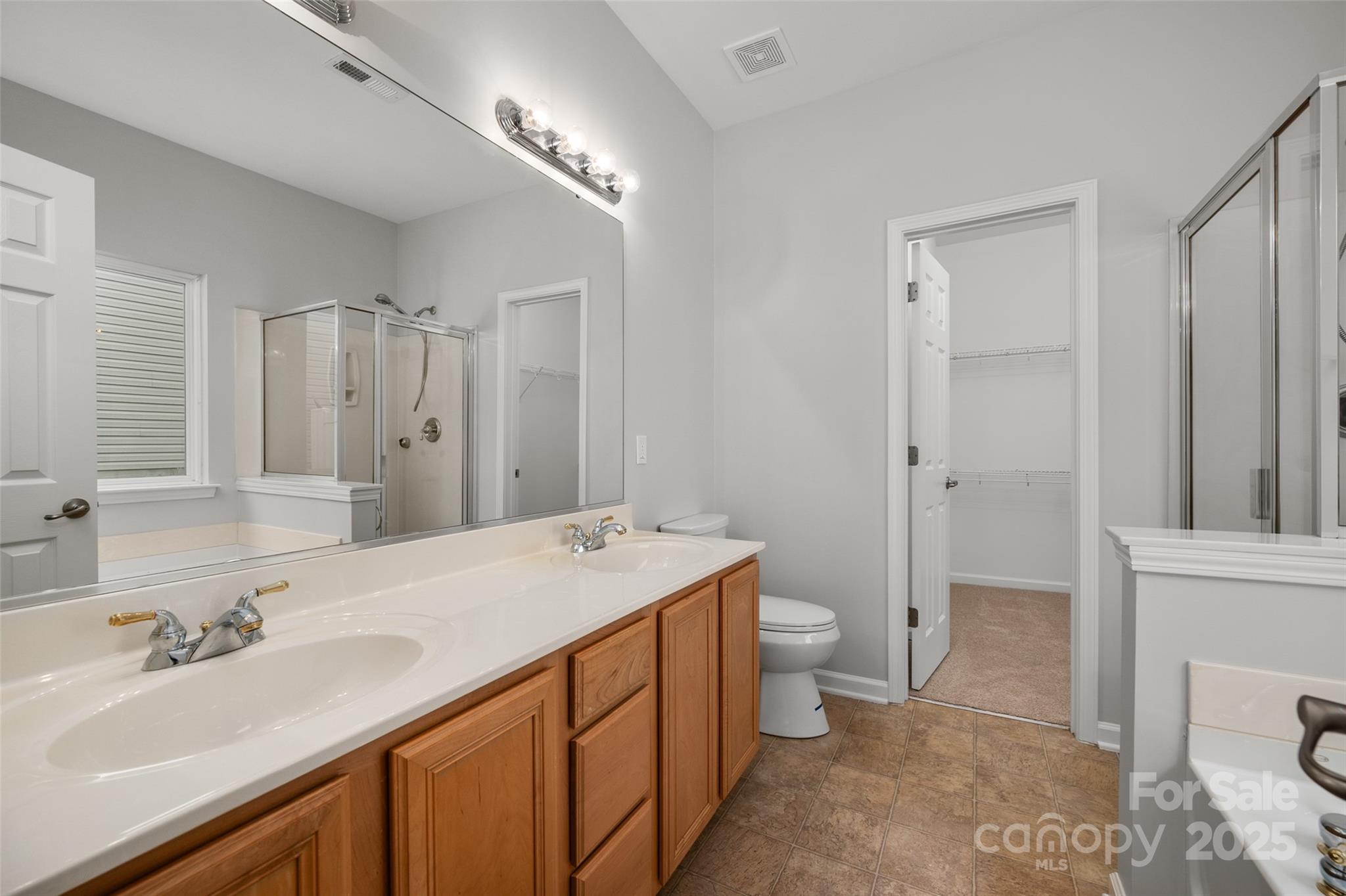 1004 Toquima Trail Monroe, NC 28110 - Photo 20 of 38 a spacious bathroom with a sink a toilet a mirror and shower