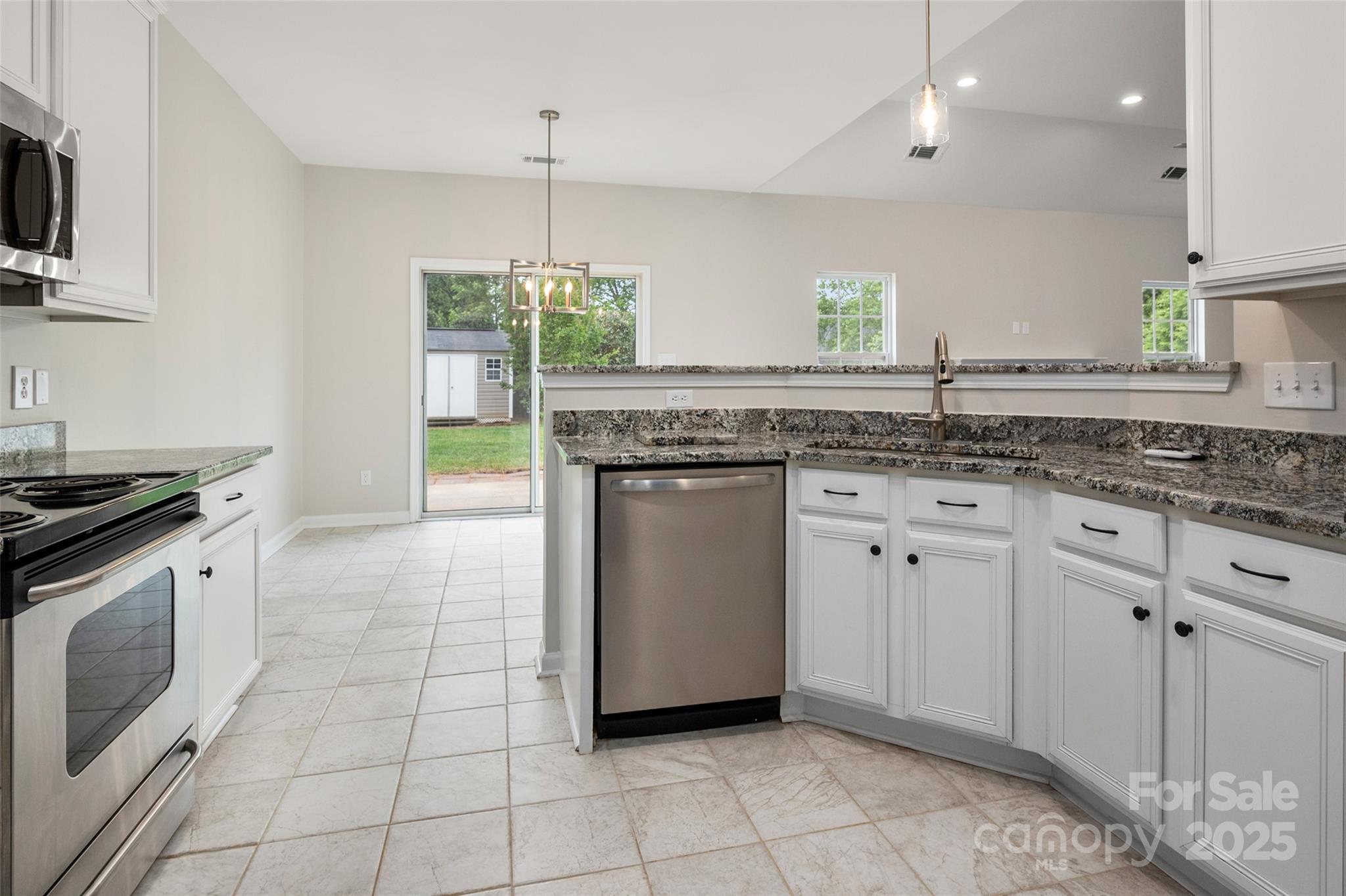 1004 Toquima Trail Monroe, NC 28110 - Photo 7 of 38 a kitchen with a stove sink and cabinets