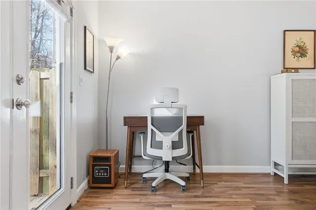 a view of a workspace with furniture and wooden floor