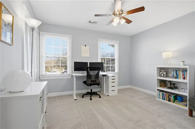 a view of a workspace with furniture and a window