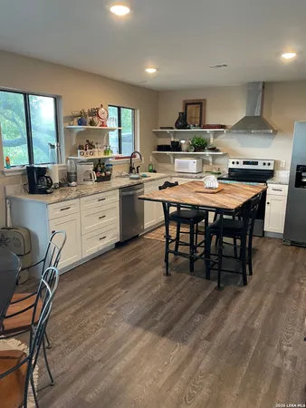 a kitchen with a table chairs stove and cabinets