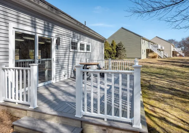 a balcony with wooden floor table and chairs