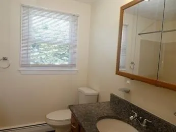 a view of empty room with cabinet and wooden floor