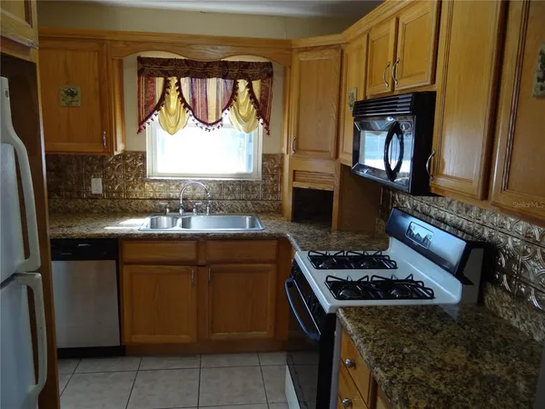 a kitchen with granite countertop a stove and a sink