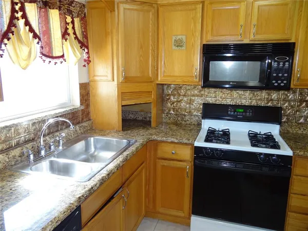 a kitchen with a sink and a stove top oven