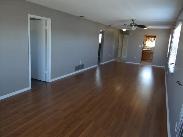 an empty room with wooden floor and mirror