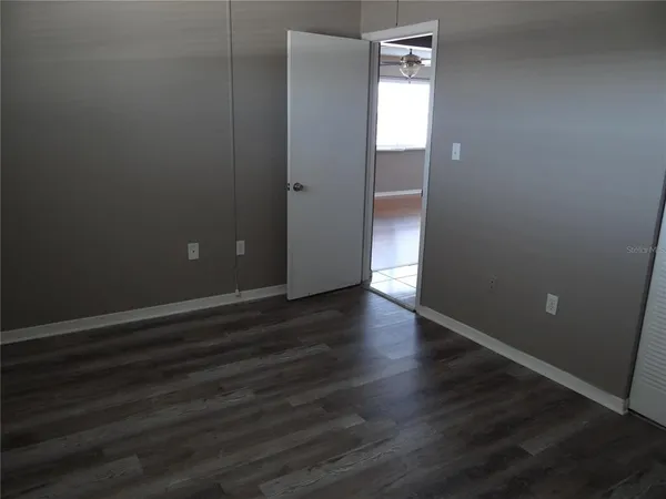an empty room with wooden floor and closet
