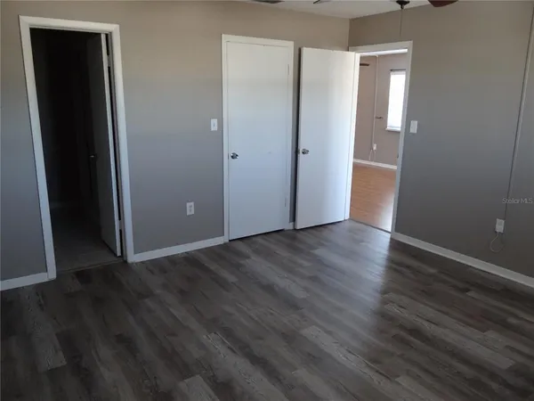 an empty room with wooden floor and closet