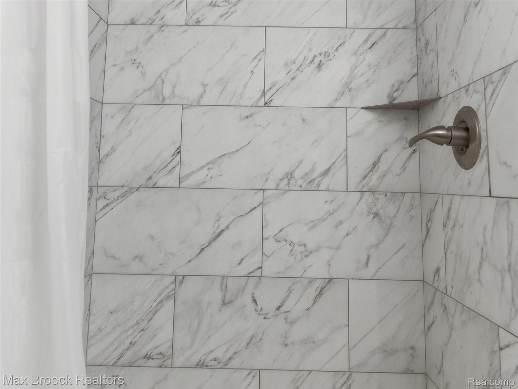 3562 Tremonte Circle Rochester, MI 48306 - Photo 19 of 33 Shower enclosure featuring large format white tile with grey veining, brushed nickel fixtures, and a built-in corner shelf