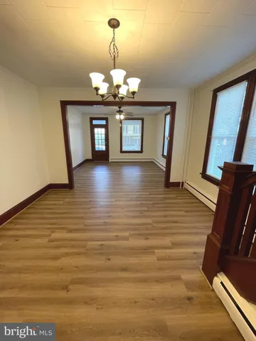 a view of a livingroom with wooden floor and chandelier