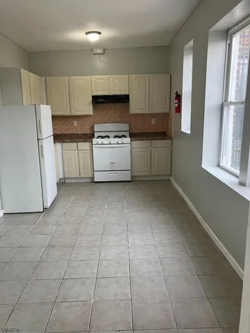 a kitchen with a cabinets a window and stainless steel appliances