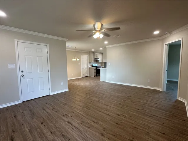 a view of empty room with wooden floor and ceiling fan