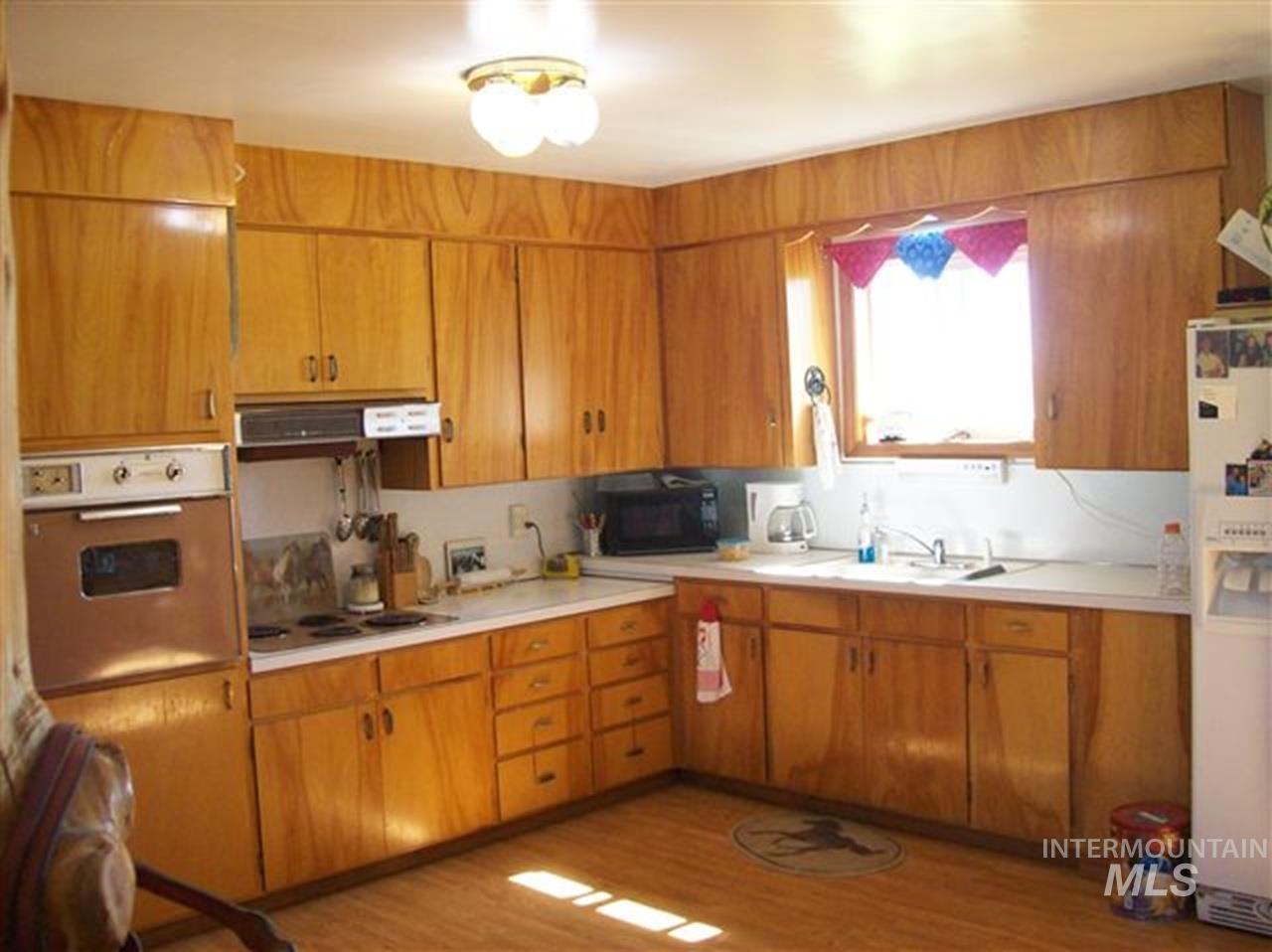 721 Mendiola Road Nyssa, OR 97913 - Photo 4 of 16 Kitchen featuring extensive wood cabinetry, white countertops, built-in wall oven, and a window above the sink