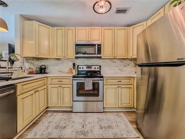 a kitchen with a refrigerator a sink and cabinets