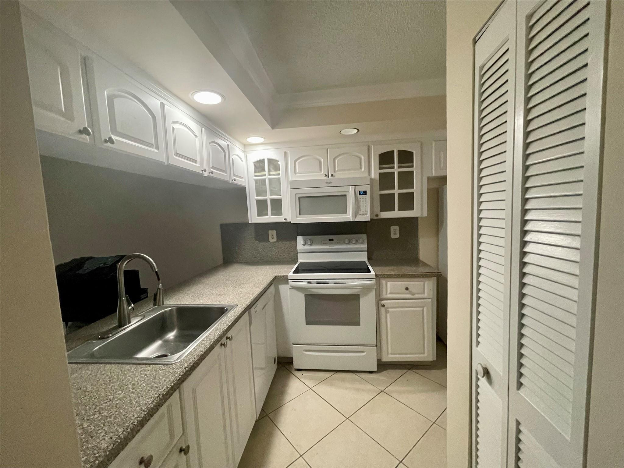 6800 Cypress Road, Unit 413 Plantation, FL 33317 - Photo 7 of 10 a kitchen that has a sink and a stove