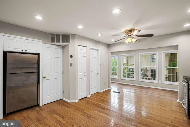 a view of an empty room with window and wooden floor