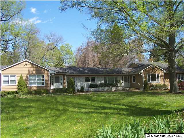 84 Rumson Road Rumson, NJ 07760 - Photo 1 of 5 a front view of a house with a yard table and chairs