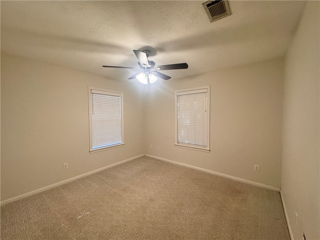 1204 Bayou Woods Drive College Station, TX 77840 - Photo 11 of 14 an empty room with ceiling fan and windows
