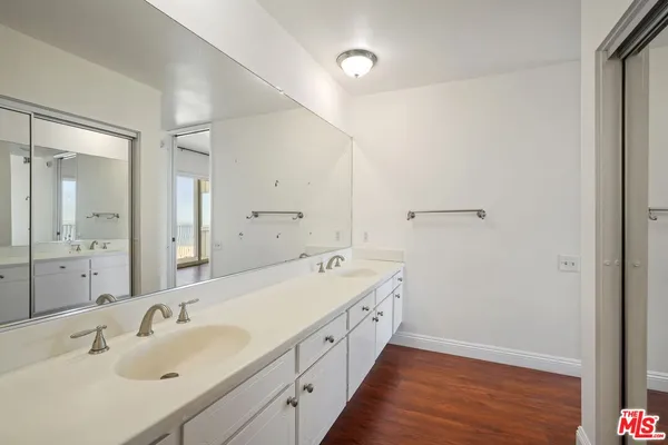 a spacious bathroom with double vanity and mirrors