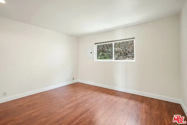 an empty room with wooden floor and a window