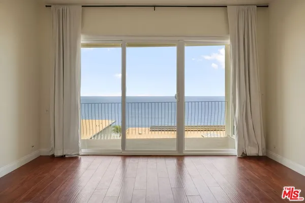 a view of a room with wooden floor and a window